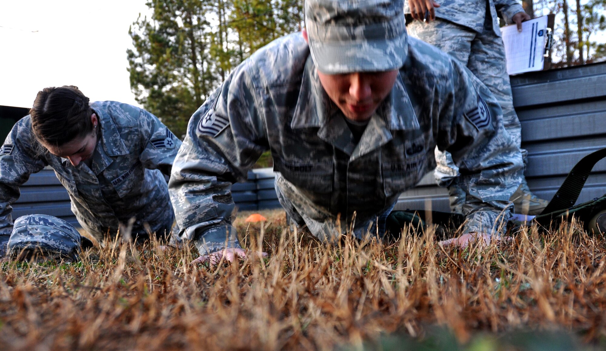 Senior Airman Jessica McMillan and Tech. Sgt. Harold Debolt, both from the 445th Force Support Squadron at Wright Patterson Air Force Base, Ohio, perform push-ups for the scavenger hunt portion of the Readiness Challenge for Force Support Silver Flag at Dobbins Air Reserve Base, Georgia, March 12, 2015. The team fired a paintball gun at a target to see how many push-ups they would have to do. (U.S. Air Force photo/Senior Airman Daniel Phelps)