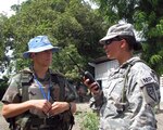 Pfc. Patricia Arnold, a member of the Nevada National Guard's 485th Military Police Company, coordinates with Argentina 2nd Lt. Francisco Moulia, whose MINUSTAH troops provide security for the government of Haiti at a medical readiness exercise at the Les Poteau clinic site near Gonaives, Haiti.