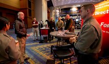 CDR Richard Newton (left) goes over the plan of the day before the show opens at the 2015 Naval Future Force Science and Technology Expo. CDR Newton and (left to right) Capt Angelica Valdez, TC Moore, Capt Brad Goldgvarg, LtCol Jody White, LtCol Patrick Kirchner, and LtCol Jeff Holt spent two days meeting with government and industry visitors at the expo to inform and educate them on the Futures Directorate and to also find potential solutions to the Marine Corps' S&T related needs.