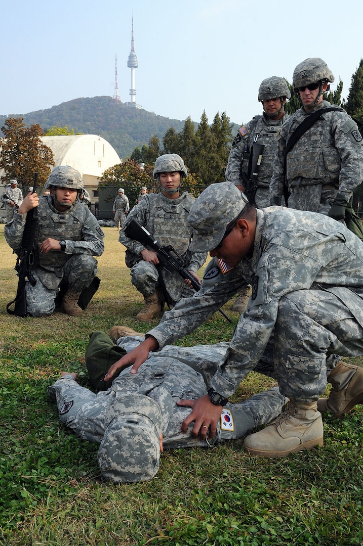 In this file photo, Sgt. Johnston Albert Jr. (right) and Cpl. Il Shin Kim, both from the 501st Special Troops Battalion, 501st Sustainment Brigade, demonstrate basic lifesaving skills to U.S. and KATUSA Soldiers during Sergeant's Time Training in October 2014 on Yongsan Garrison, Republic of Korea.

