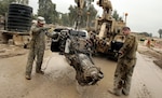 Mechanics with Regimental Fires Squadron of the Tennessee National Guard's 278th Armored Cavalry Regiment, 13th Sustainment Command (Expeditionary) clean a Mine-Resistant Ambush-Protected vehicle engine prior to re-installing it at Contingency Operating Base Marez, Iraq.