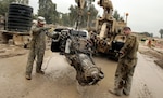 Mechanics with Regimental Fires Squadron of the Tennessee National Guard's 278th Armored Cavalry Regiment, 13th Sustainment Command (Expeditionary) clean a Mine-Resistant Ambush-Protected vehicle engine prior to re-installing it at Contingency Operating Base Marez, Iraq.