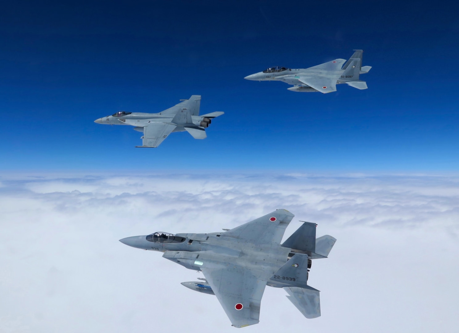 In this file photo, an F/A-18E (left) of the "Royal Maces" of Strike Fighter Squadron (VFA) 27 flies in formation with two Japan Air Self-Defense Force F-15J Eagles during a dissimilar air combat training near Okinawa, Japan. VFA-27 is part of Carrier Air Wing 5 and forward-deployed to Naval Air Facility Atsugi, Japan. 