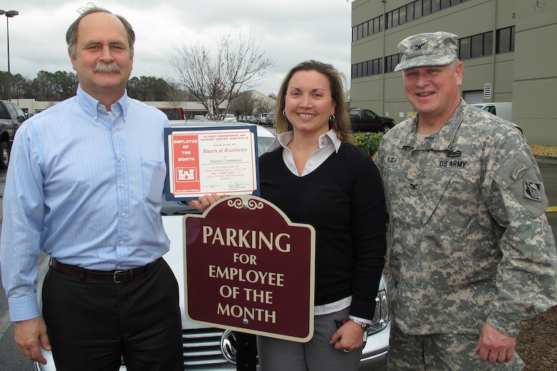 Tammy Cinnamon, an employee at the Army Corps of Engineers, Huntsville Center receives award recognition and designated parking space at the organization from Huntsville Center Commander, Col. Robert Ruch and deputy for programs, Charles Ford.