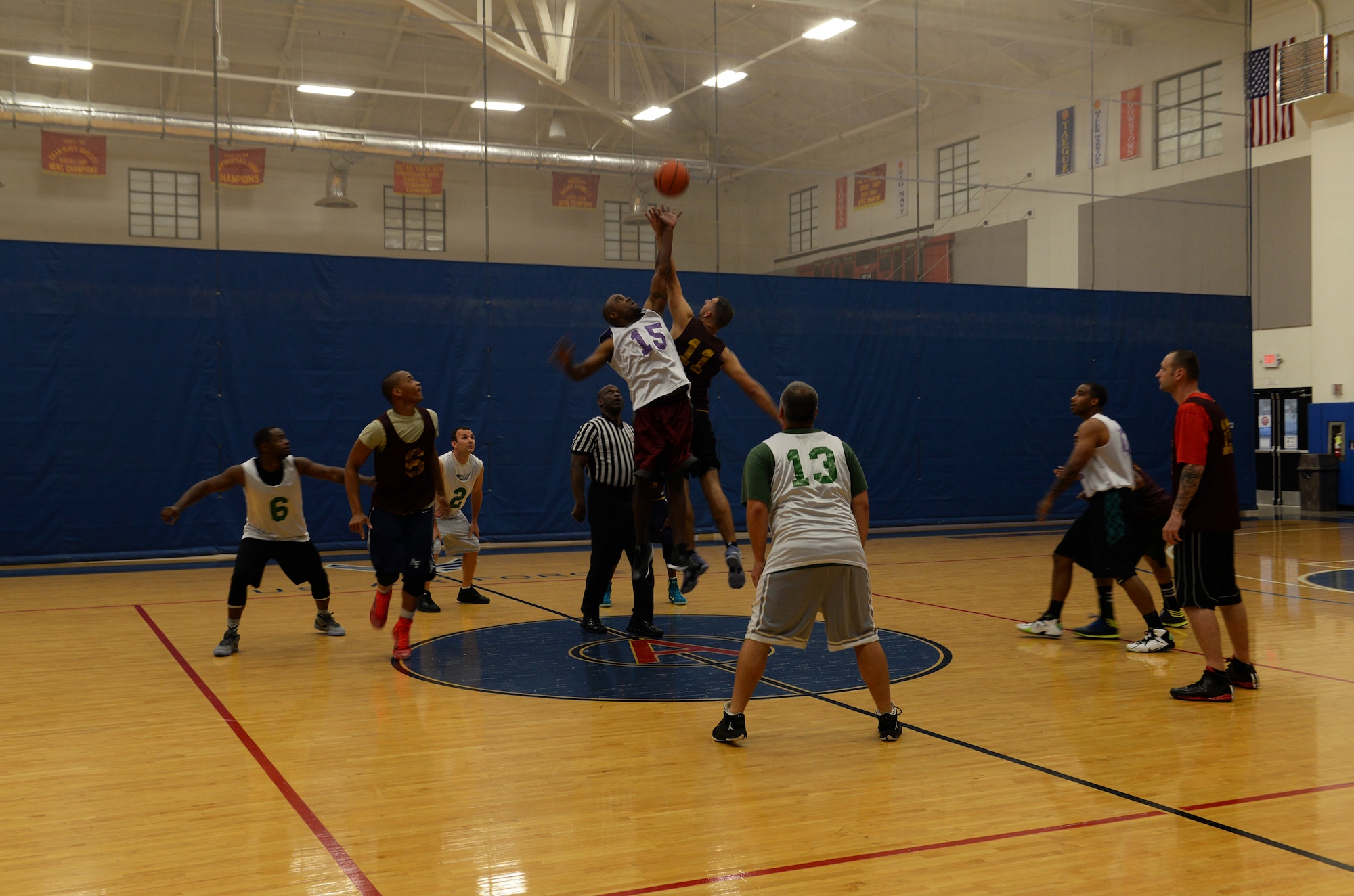 Members of the 36th Security Forces Squadron and 36th Medical Group begin the over-thirty basketball championship with jump ball March 12, 2015, at Andersen Air Force Base, Guam.  The 36th SFS defeated the 36th MDG 57-56 to win the championship overall. (U.S. Air Force photo by Senior Airman Amanda Morris/Released)