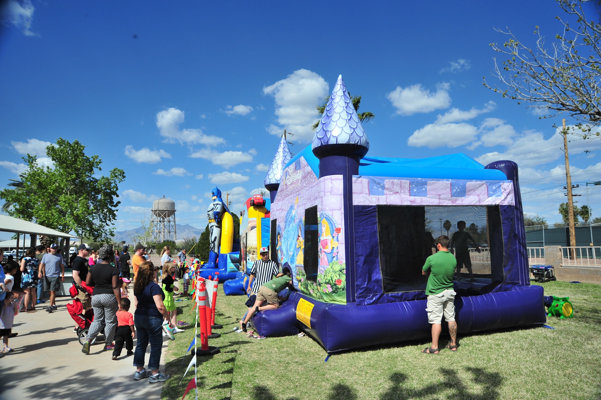 Children line up to play in multiple bounce houses during the DM50 picnic at Davis-Monthan Air Force Base, Ariz., March 14, 2015. Approximately 3,600 people attended the picnic which provided free entertainment, food and events. (U.S. Air Force photo by Airman 1st Class Christopher Massey/Released)