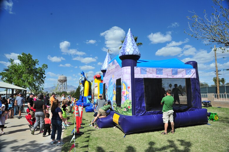 Children line up to play in multiple bounce houses during the DM50 picnic at Davis-Monthan Air Force Base, Ariz., March 14, 2015. Approximately 3,600 people attended the picnic which provided free entertainment, food and events. (U.S. Air Force photo by Airman 1st Class Christopher Massey/Released)