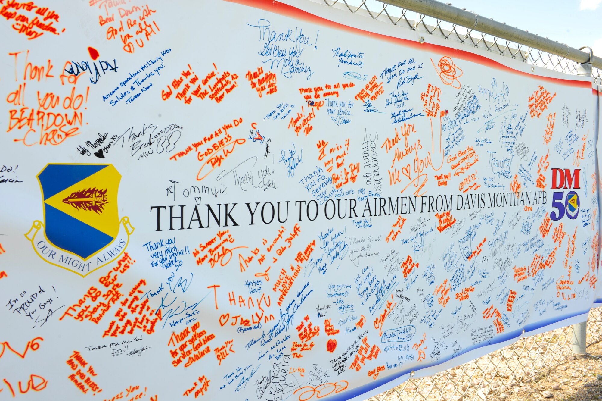 A thank-you sign from the DM50 hangs on a fence during the DM50 picnic sign at Davis-Monthan Air Force Base, Ariz., March 14, 2015. The picnic was free for active duty members, families, retirees and any guests sponsored onto the base. (U.S. Air Force photo by Staff Sgt. Angela Ruiz/Released)