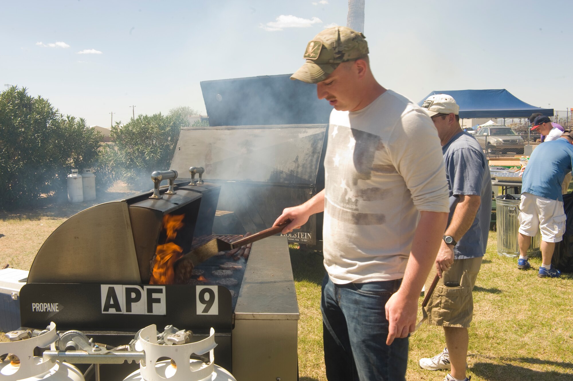U.S. Air Force Senior Airman Tim Schott grills hamburgers during the DM50 picnic at Davis-Monthan Air Force Base, Ariz., March 14, 2015. Approximately 3,600 people attended the picnic. (U.S. Air Force photo by Staff Sgt. Angela Ruiz/Released/Released)