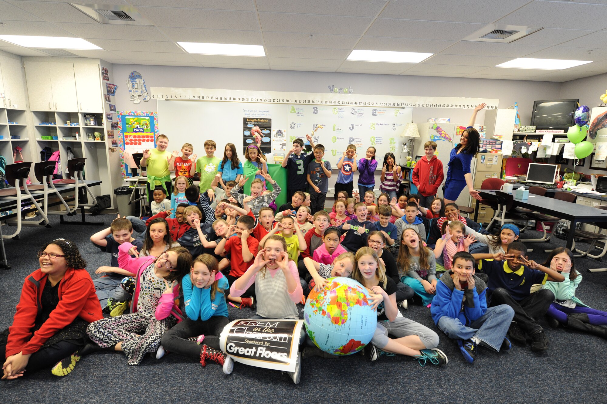 Katie Boer, KREM 2 NEWS weather anchor, Michael Anderson Elementary School staff and students make funny faces for a group photo March 18, 2015, at Fairchild Air Force Base, Wash. Boer visited the school as part of “KREM in the Classroom” where anchors visit students and give them hands-on learning experience. (U.S. Air Force photo/Airman 1st Class Nicolo J. Daniello)