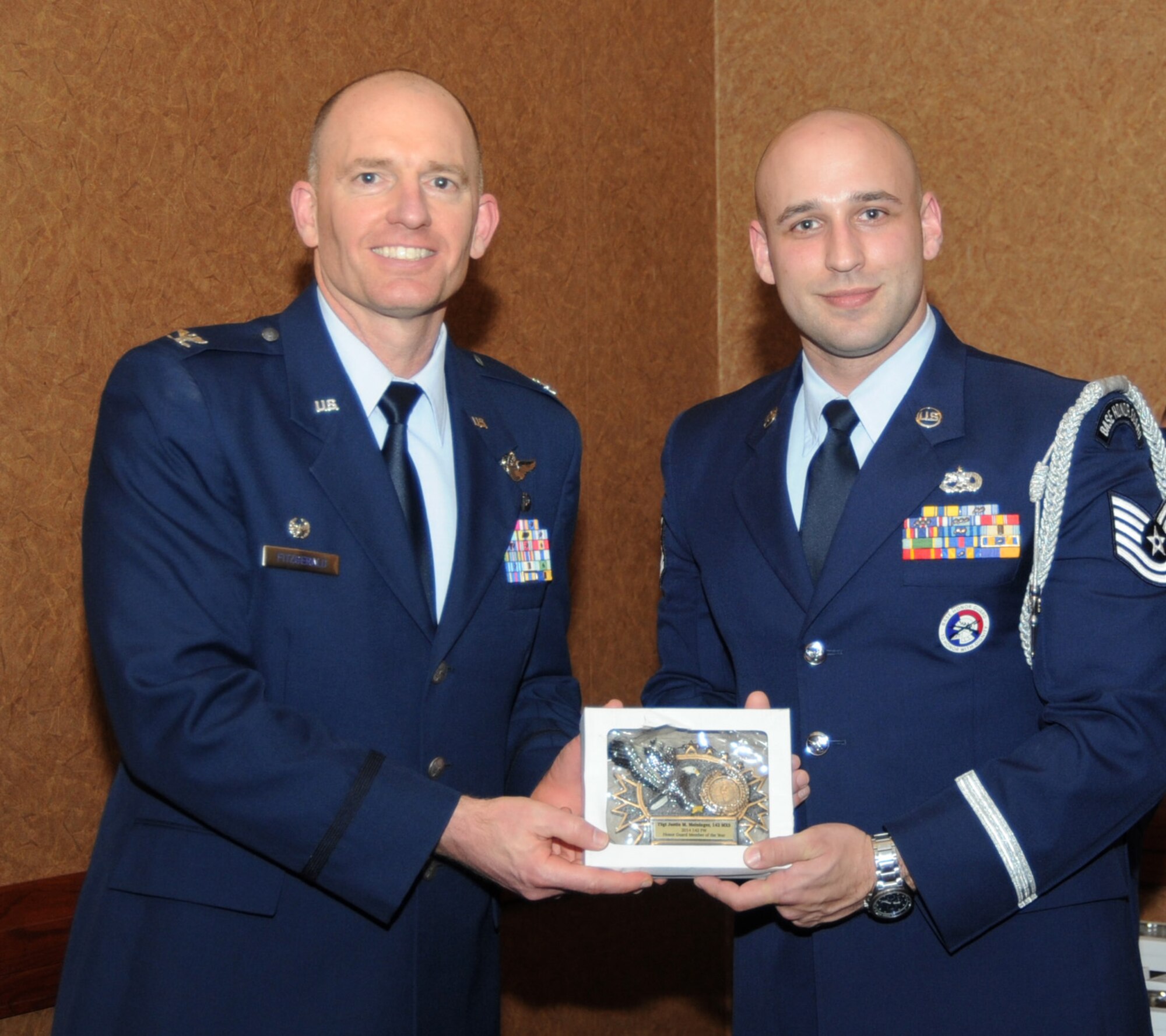 Oregon Air National Guard Col. Paul Fitzgerald, 142nd Fighter Wing commander, left, presents the 142nd Fighter Wing Honor Guard Member of the Year Award to Tech. Sgt. Justin Meininger, assigned to the 142nd Maintenance Group, right, during the 21st Annual Oregon Air National Guard Awards Banquet, March 14, 2015, Portland, Ore. (U.S. Air National Guard photo by Tech. Sgt. Emily Thompson, 142nd Fighter Wing Public Affairs/Released)