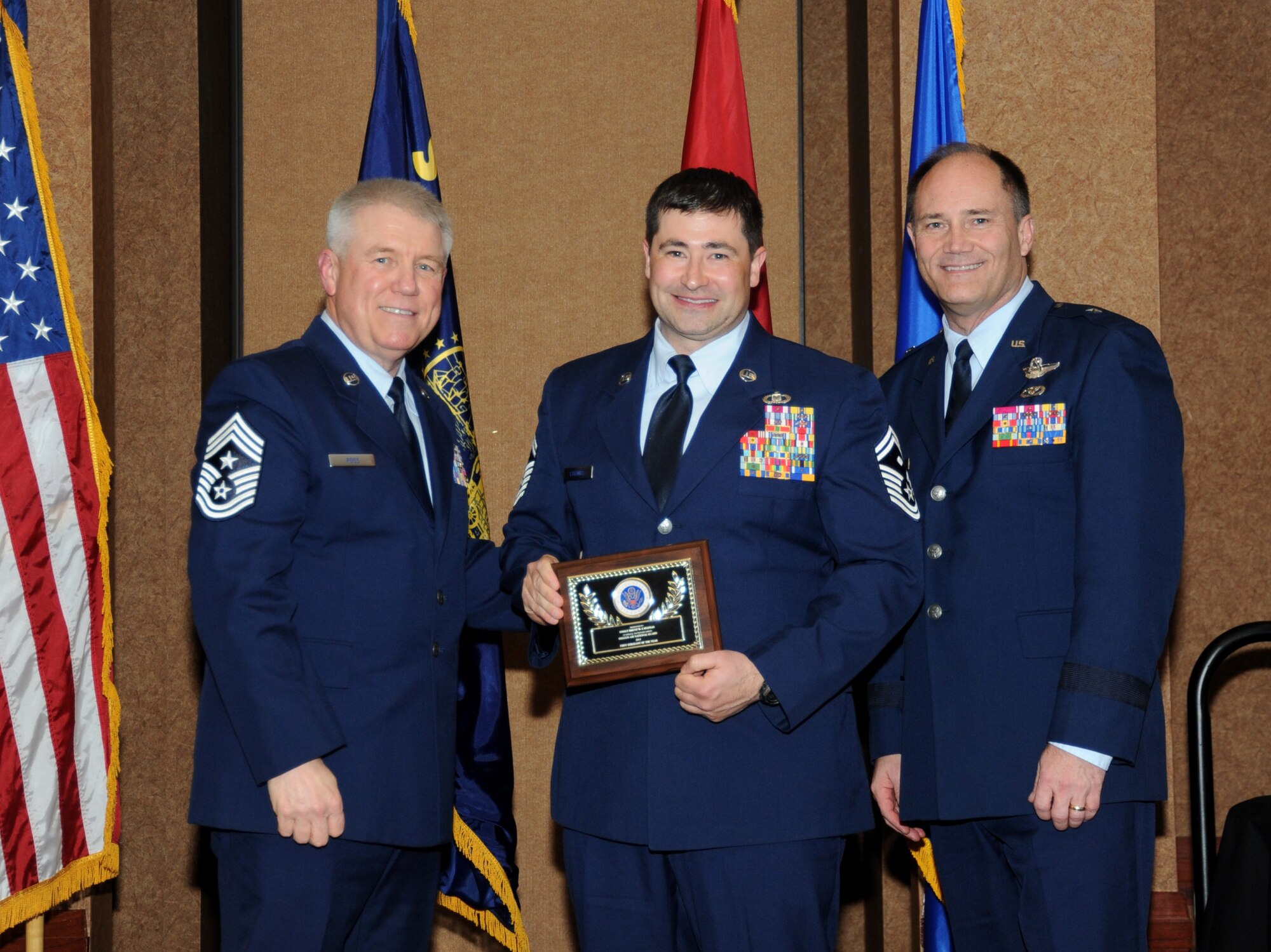 Oregon Air National Guard Senior Master Sgt. Brent Cavanias, assigned to the 125th Special Tactics Squadron, center, is presented with the overall Oregon Air National Guard First Sergeant of the Year  Award, from 173rd Fighter Wing Command Chief Master Sgt. Danny Ross, left, and Air Component Commander Brig. Gen. Michael Stencel, right, during the 21st Annual Oregon Air National Guard Awards Banquet, March 14, 2015, Portland, Ore. (U.S. Air National Guard photo by Tech. Sgt. Emily Thompson, 142nd Fighter Wing Public Affairs/Released)