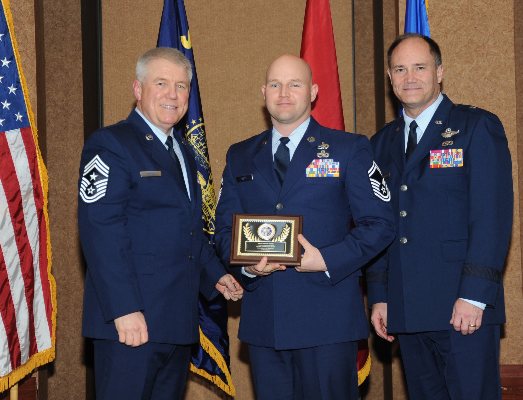 Oregon Air National Guard Senior Master Sgt. Jason Witts, assigned to the 173rd Logistical Readiness Squadron, center, is presented with the overall Oregon Air National Guard Outstanding Airman of the Year Award,  Category III, from 173rd Fighter Wing Command Chief Master Sgt. Danny Ross, left, and Air Component Commander Brig. Gen. Michael Stencel, right, during the 21st Annual Oregon Air National Guard Awards Banquet, March 14, 2015, Portland, Ore. (U.S. Air National Guard photo by Tech. Sgt. Emily Thompson, 142nd Fighter Wing Public Affairs/Released)