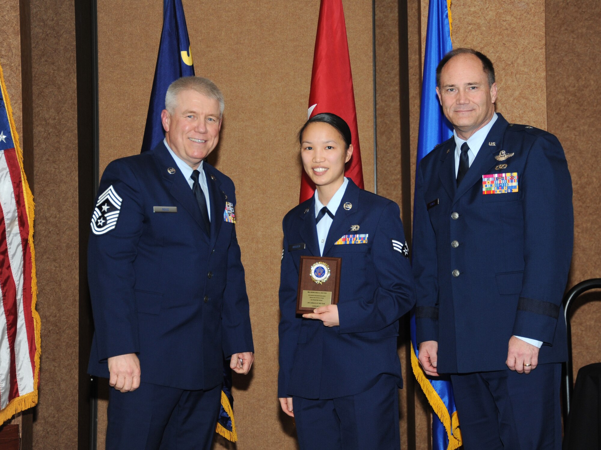 Oregon Air National Guard Senior Airman Hongmai Nguyen, center, is presented with the overall 142nd Fighter Wing Airman of the Year Award for Category I, from 173rd Fighter Wing Command Chief Master Sgt. Danny Ross, left, and Air Component Commander Brig. Gen. Michael Stencel, right, during the 21st Annual Oregon Air National Guard Awards Banquet, March 14, 2015, Portland, Ore. (U.S. Air National Guard photo by Tech. Sgt. Emily Thompson, 142nd Fighter Wing Public Affairs/Released)