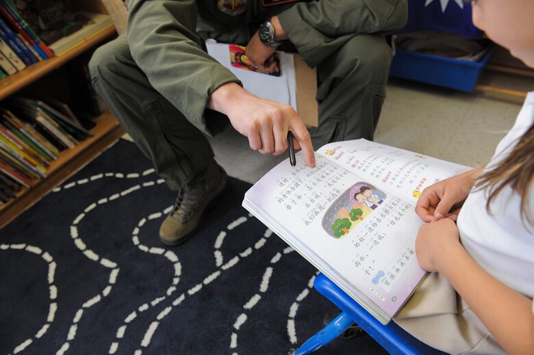 U.S. Air Force Tech. Sgt. Jonathan Roe, 55th Electronic Combat Group Chinese linguist, helps a student complete schoolwork at the International School of Tucson in Tucson, Ariz., March 11, 2015. Assisting the students helps Roe maintain proficiency in the Chinese language while allowing him to give back to the local community. (U.S. Air Force photo by Airman 1st Class Chris Drzazgowski/Released)