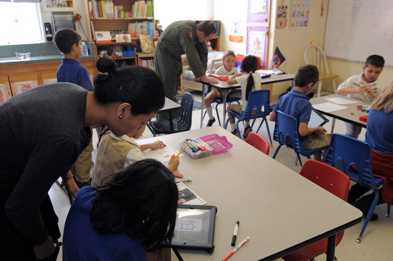 Hsin-Fen Chang, International School of Tucson junior Chinese teacher, and Tech. Sgt. Jonathan Roe, 55th Electronic Combat Group Chinese linguist, assist students at the International School of Tucson in Tucson, Ariz., March 11, 2015. The school aims to teach foreign languages and traditional elementary academics at an early age. (U.S. Air Force photo by Airman 1st Class Chris Drzazgowski/Released)