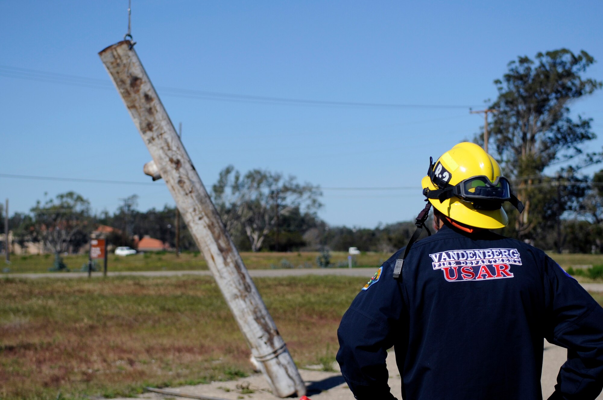 Robert McCoy, 30th Civil Engineer Squadron firefighter, observes proper crane operations during Heavy Equipment and Rigging Specialist training, March 12, 2015, Vandenberg Air Force Base, Calif. The training covered the use of heavy equipment in the event of an earthquake structural collapse scenario. (U.S. Air Force photo by Senior Airman Shane Phipps/Released)