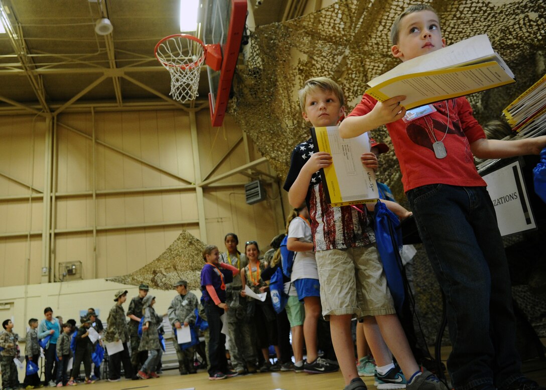 Children line up as they process through the deployment line during the Jr. Raptor event March 14 at Tyndall. Various stations were setup to provide children with information on their mock deployment. (U.S. Air Force photo by Airman 1st Class Ty-Rico Lea/Released)