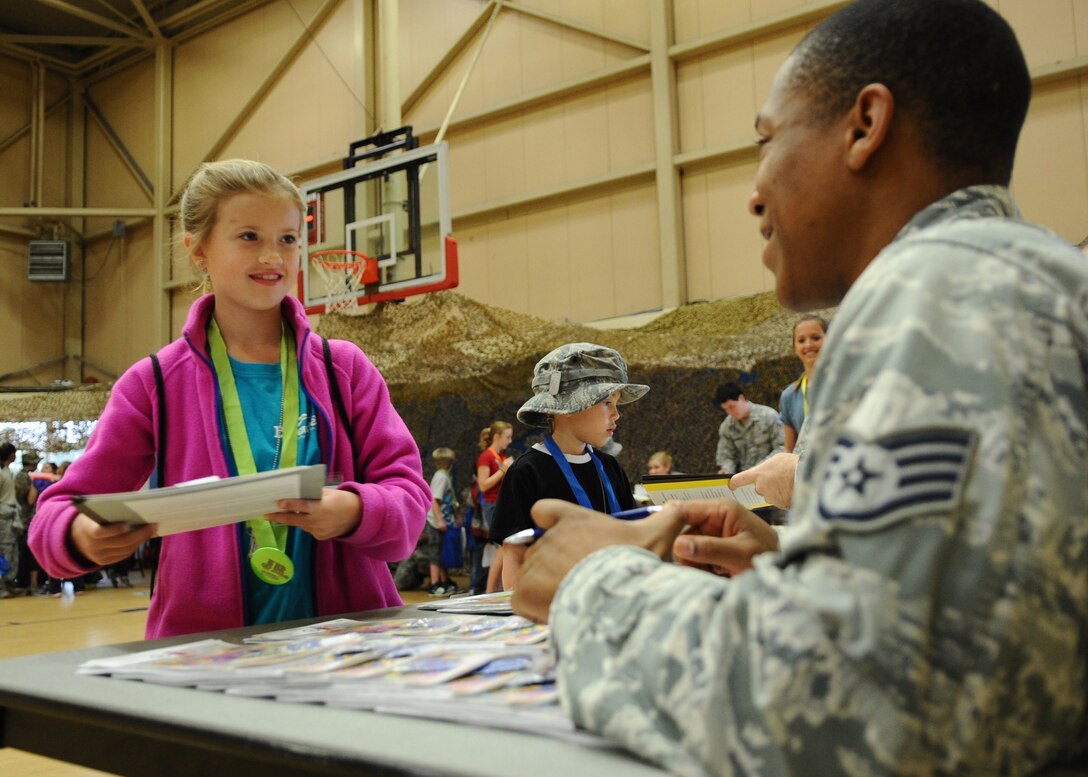 Addyson Lloyd, age 9 and daughter of Master Sgt. Adam Lloyd, 325th Aerospace Medicine Squadron bioenvironmental engineering flight chief, speaks with Staff Sgt. Jumaane Sweat, 83rd Fighter Weapons Squadron weapon systems evaluation program evaluator, during the Jr. Raptor event March 14 at Tyndall. Children processed through a deployment line preparing themselves for their departure as part of their time at Tyndall. (U.S. Air Force photo by Airman 1st Class Ty-Rico Lea/Released)