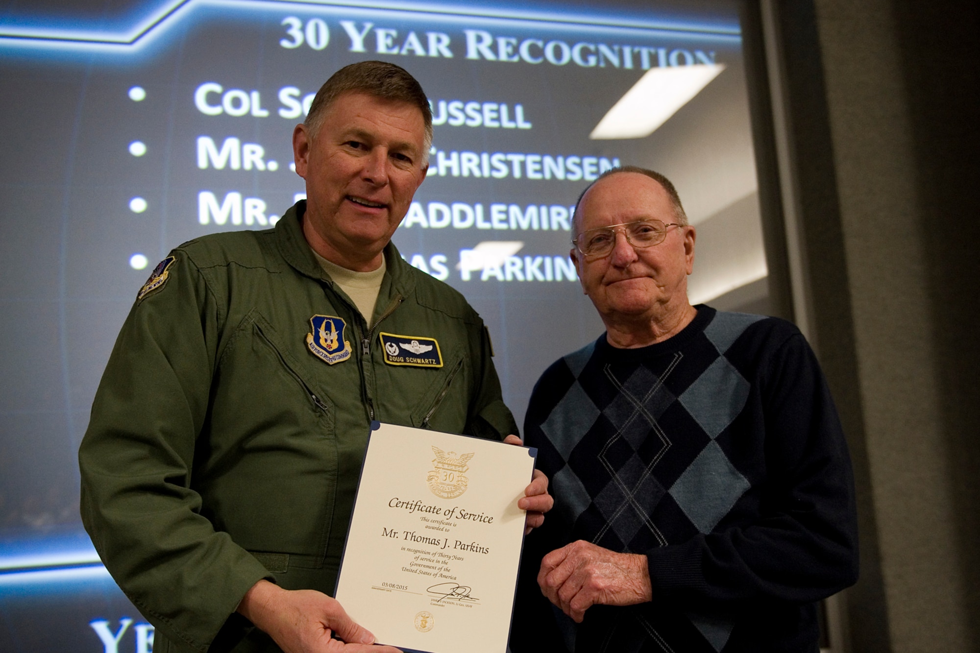 Col. Doug Schwartz, 434th Air Refueling Wing commander, presents Thomas Parkins, 434th Civil Engineer Squadron, with a certificate of service for completing 30 years as a federal employee during a civilian commander's call at Grissom Air Reserve Base, Ind., March. 13, 2015. Civil service employees are an essential part Grissom and serve critical roles in maintaining unit readiness and daily operations. (U.S. Air Force photo/Tech. Sgt. Benjamin Mota)