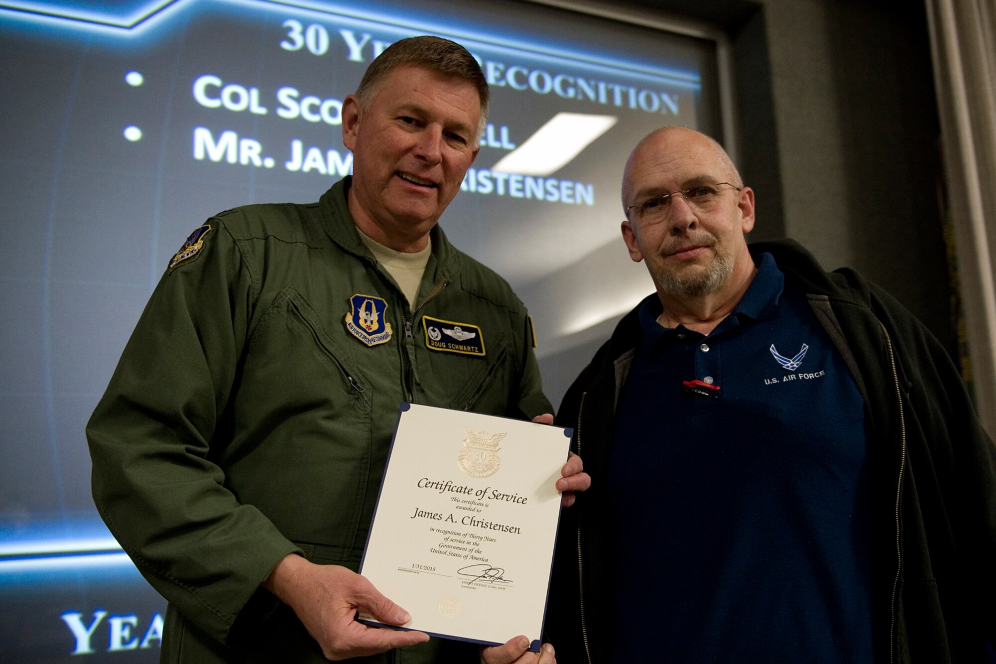 Col. Doug Schwartz, 434th Air Refueling Wing commander, presents James Christensen, 434th Civil Engineer Squadron, with a certificate of service for completing 30 years as a federal employee during a civilian commander's call at Grissom Air Reserve Base, Ind., March. 13, 2015. Civil service employees are an essential part Grissom and serve critical roles in maintaining unit readiness and daily operations. (U.S. Air Force photo/Tech. Sgt. Benjamin Mota)