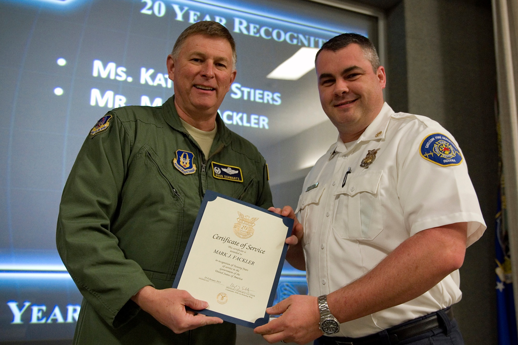 Col. Doug Schwartz, 434th Air Refueling Wing commander, presents Mark Fackler, 434th Civil Engineer Squadron, with a certificate of service for completing 20 years as a federal employee during a civilian commander's call at Grissom Air Reserve Base, Ind., March. 13, 2015. Civil service employees are an essential part Grissom and serve critical roles in maintaining unit readiness and daily operations. (U.S. Air Force photo/Tech. Sgt. Benjamin Mota)