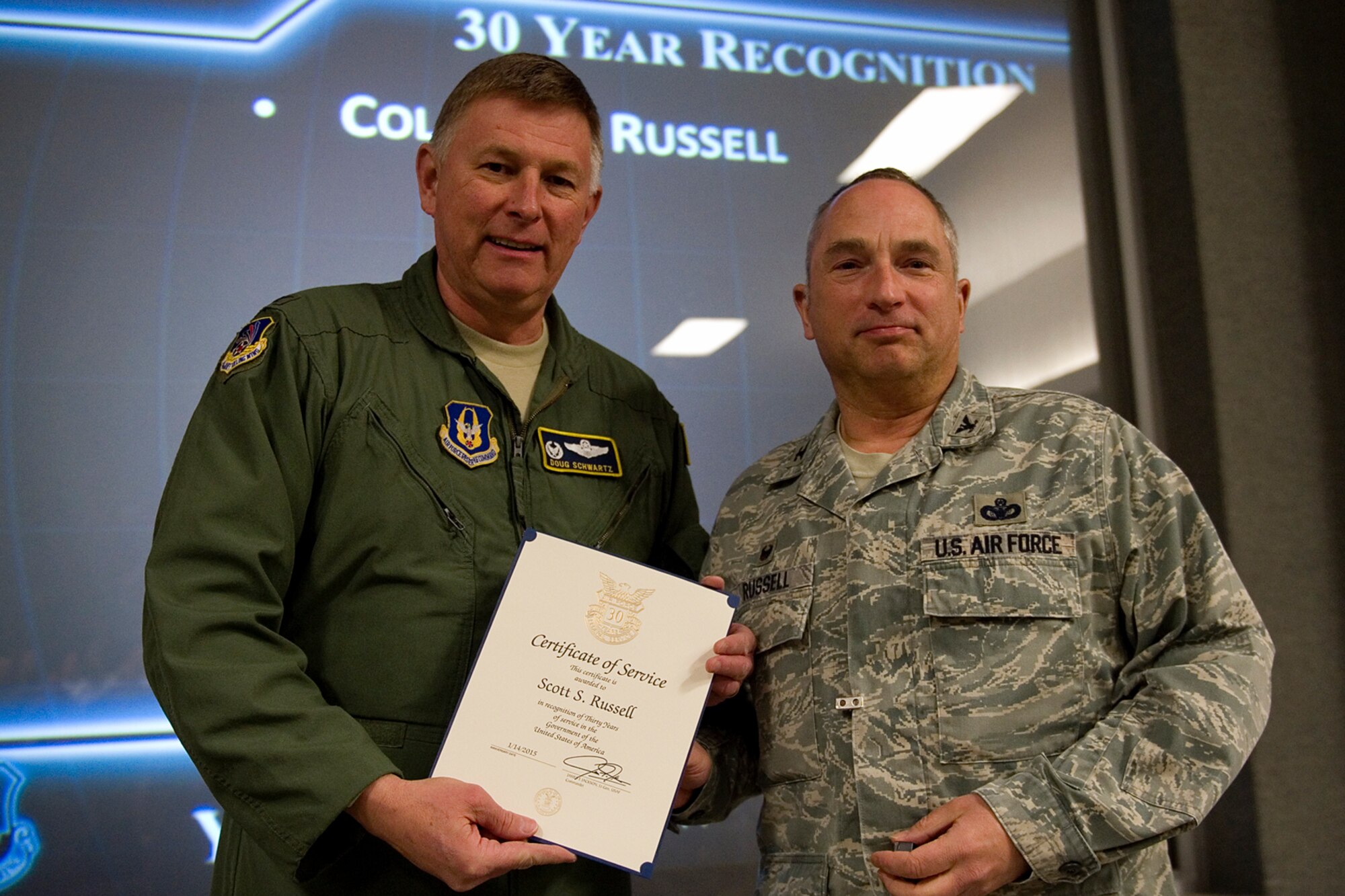 Col. Doug Schwartz, 434th Air Refueling Wing commander, presents Col. Scott Russell, 434th Mission Support Group, with a certificate of service for completing 30 years as a federal employee during a civilian commander's call at Grissom Air Reserve Base, Ind., March. 13, 2015. Civil service employees are an essential part Grissom and serve critical roles in maintaining unit readiness and daily operations. (U.S. Air Force photo/Tech. Sgt. Benjamin Mota)