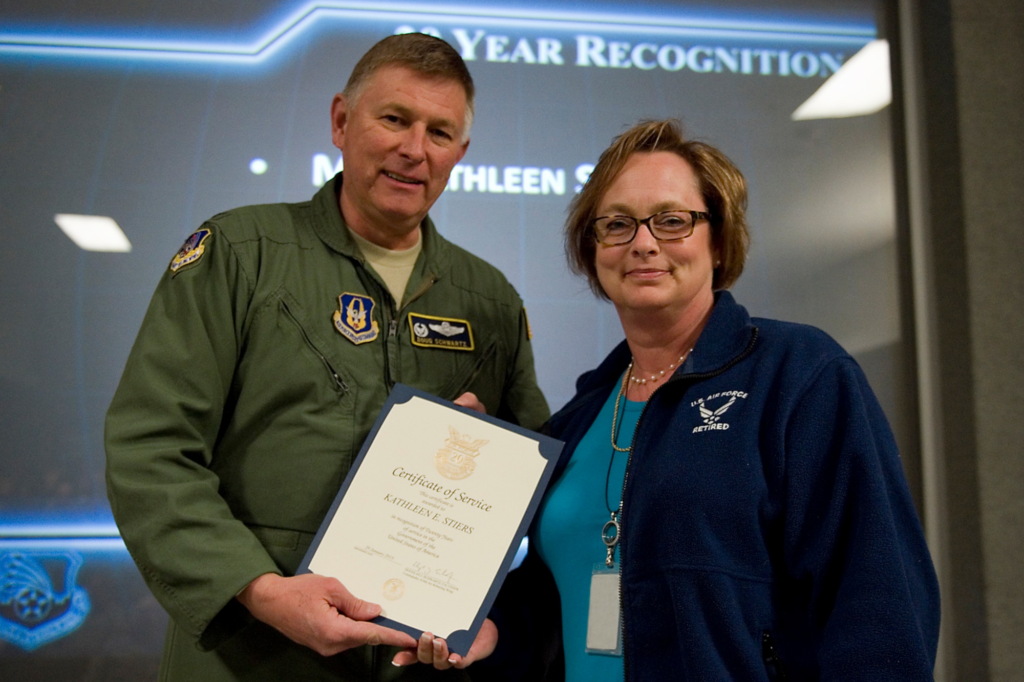 Col. Doug Schwartz, 434th Air Refueling Wing commander, presents Kathleen Stiers, 434th Maintenance Squadron, with a certificate of service for completing 20 years as a federal employee during a civilian commander's call at Grissom Air Reserve Base, Ind., March. 13, 2015. Civil service employees are an essential part Grissom and serve critical roles in maintaining unit readiness and daily operations. (U.S. Air Force photo/Tech. Sgt. Benjamin Mota)