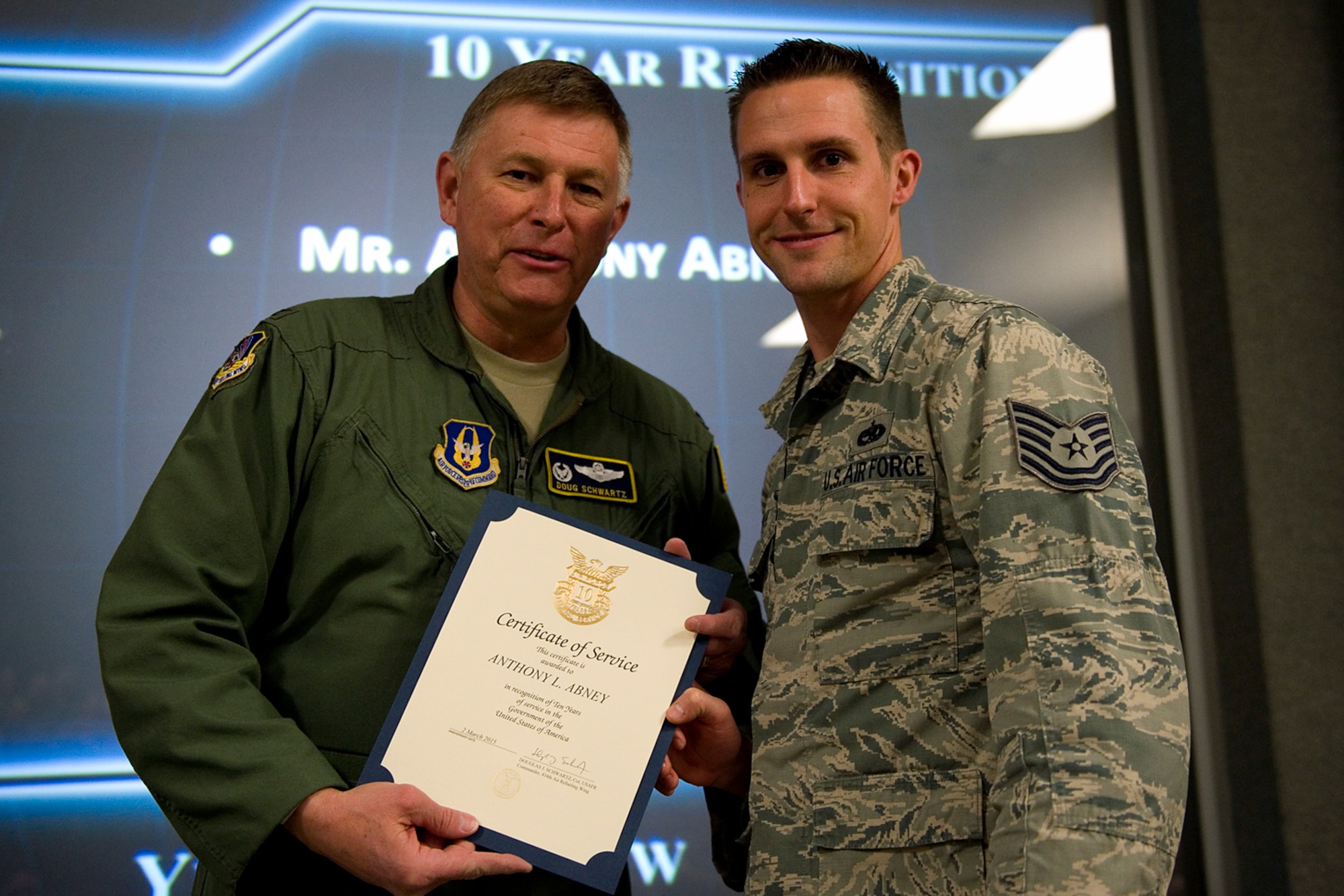 Col. Doug Schwartz, 434th Air Refueling Wing commander, presents Tech. Sgt. Anthony Abney, 434th Maintenance Squadron, with a certificate of service for completing 10 years as a federal employee during a civilian commander's call at Grissom Air Reserve Base, Ind., March. 13, 2015. Civil service employees are an essential part Grissom and serve critical roles in maintaining unit readiness and daily operations. (U.S. Air Force photo/Tech. Sgt. Benjamin Mota)