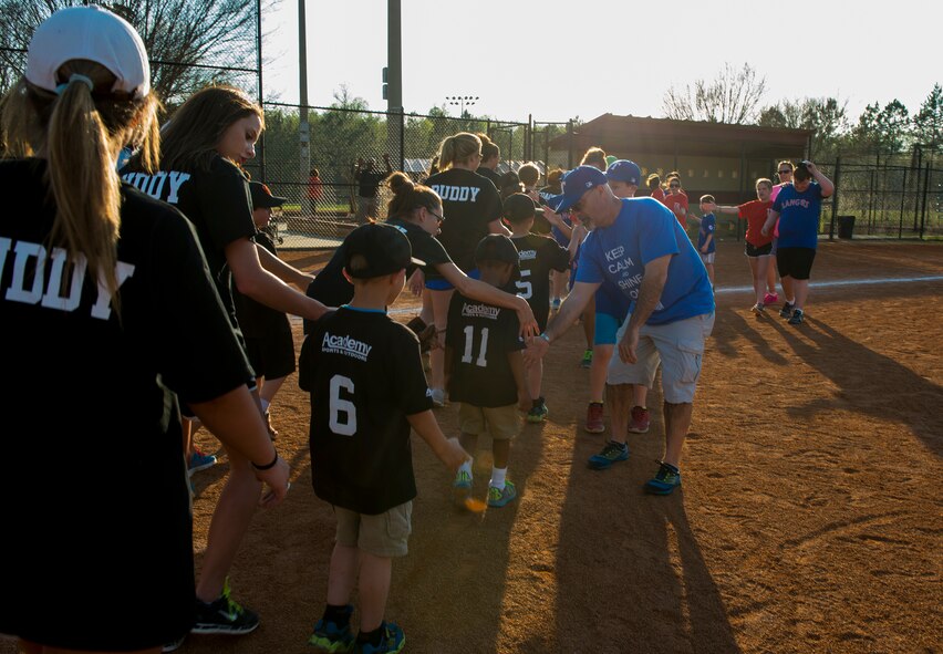 Derrick Harris, 23d Force Support Squadron casualty assistance and survivor benefit plan representative and Rangers team coach, shakes hands with the opposing team during the Miracle League of Valdosta’s baseball game March 17, 2015, in Valdosta, Ga. The league has 83 players comprised of both disabled youth and adults. The players are divided up into eight different teams, which include four youth teams and four adult teams. (U.S. Air Force photo by Airman 1st Class Ceaira Tinsley/Released)