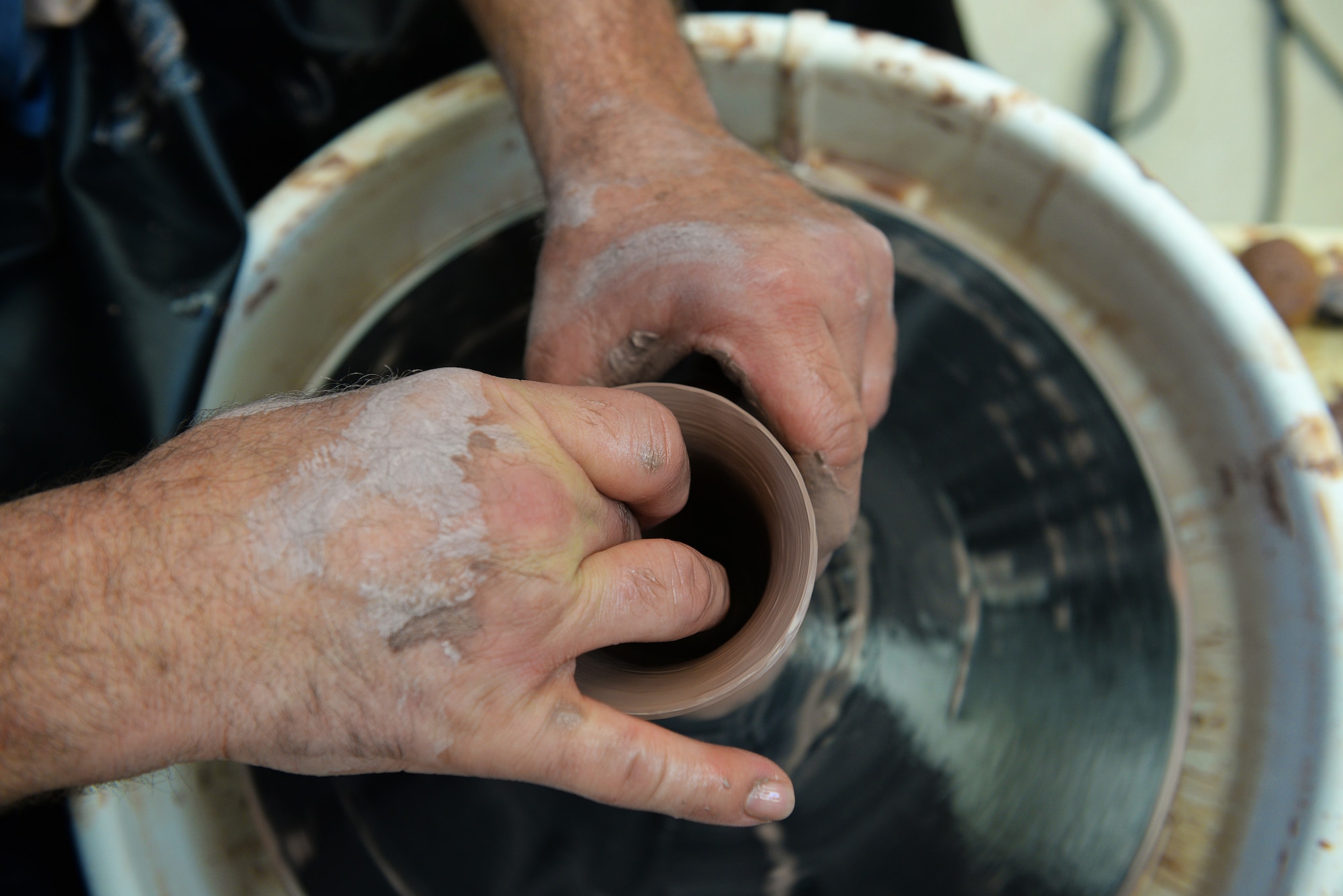 Norman Wiggins, Pottery Instructor at the Scott Air Force Base Arts and Crafts Center, works with clay as he will at the upcoming Arts and Crafts Center Open House, Scott Air Force Base, Illinois, March 13, 2015. Interested individuals are free to try out the pottery wheel themselves at the open house. The open house is March 21, 2015 from 9 to 4, and will feature 23 artisans showcasing different crafts and hobbies. (U.S. Air Force photo by Airman 1st Class Erica Crossen)