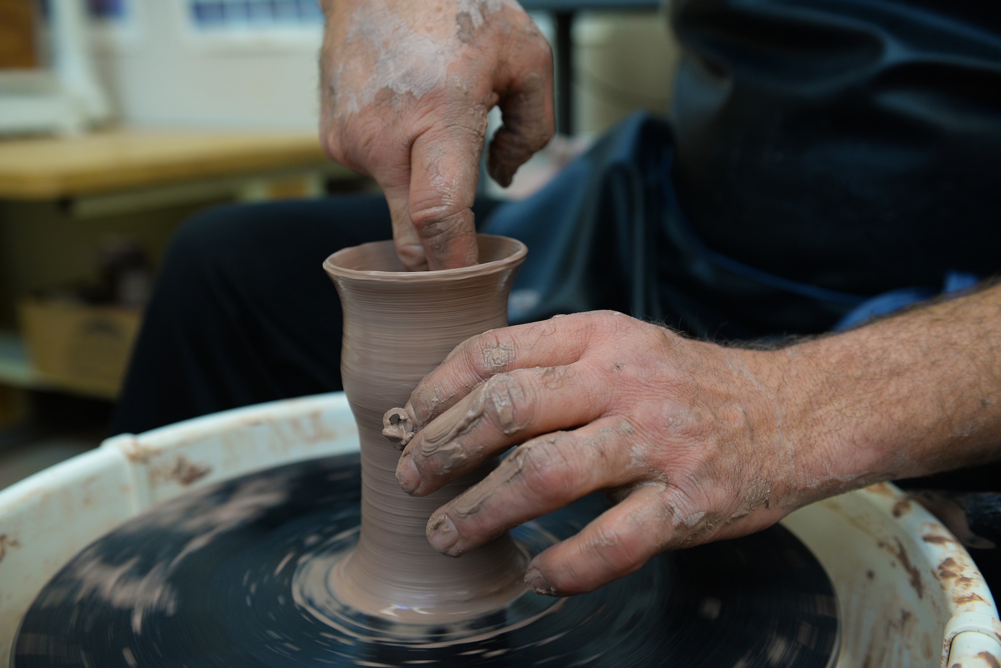 Norman Wiggins, Pottery Instructor at the Scott Air Force Base Arts and Crafts Center, works with clay as he will at the upcoming Arts and Crafts Center Open House, Scott Air Force Base, Illinois, March 13, 2015. Interested individuals are free to try out the pottery wheel themselves at the open house. The open house is March 21, 2015 from 9 to 4, and will feature 23 artisans showcasing different crafts and hobbies. (U.S. Air Force photo by Airman 1st Class Erica Crossen)