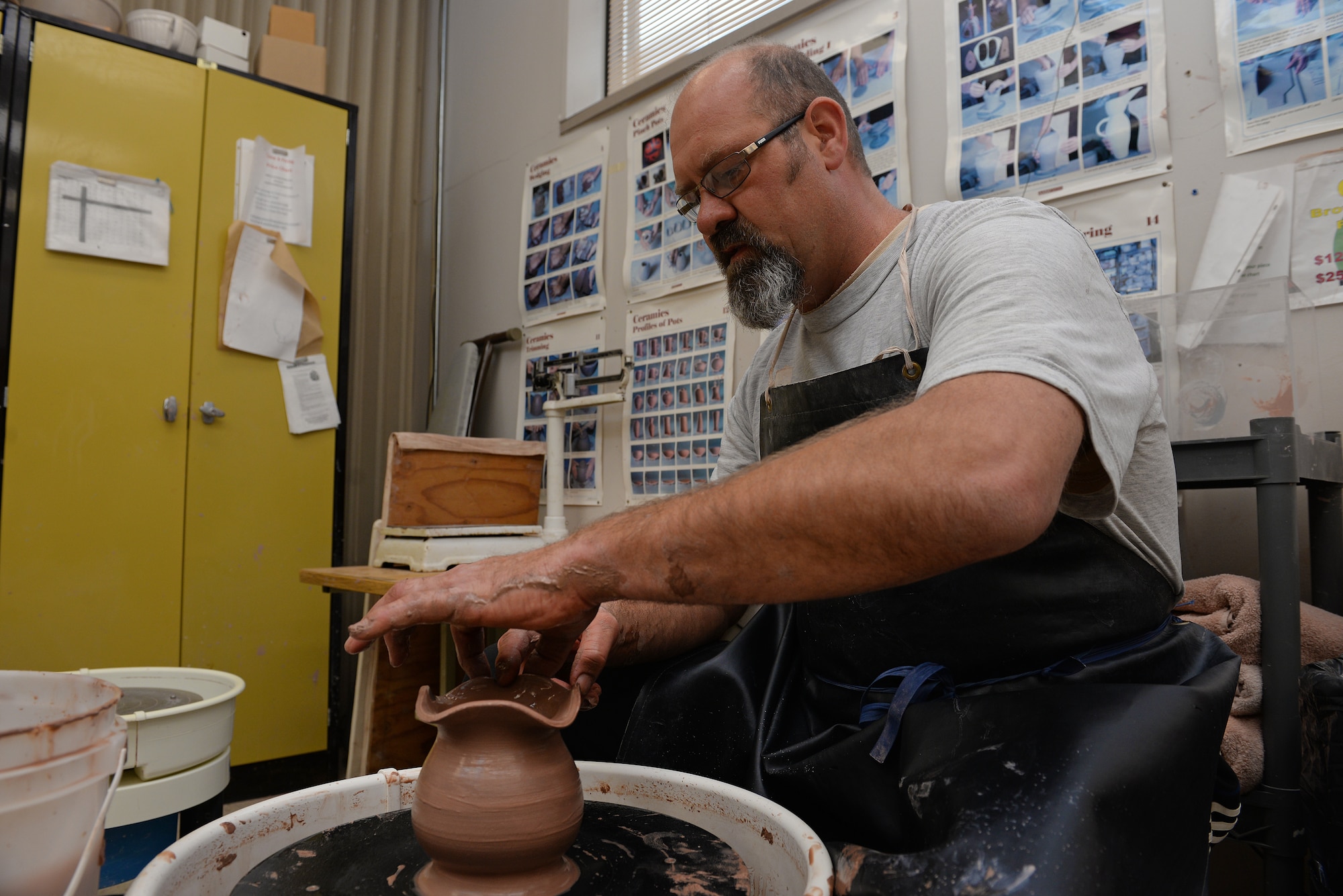 Norman Wiggins, Pottery Instructor at the Scott Air Force Base Arts and Crafts Center, works with clay as he will at the upcoming Arts and Crafts Center Open House, Scott Air Force Base, Illinois, March 13, 2015. Interested individuals are free to try out the pottery wheel themselves at the open house. The open house is March 21, 2015 from 9 to 4, and will feature 23 artisans showcasing different crafts and hobbies. (U.S. Air Force photo by Airman 1st Class Erica Crossen)