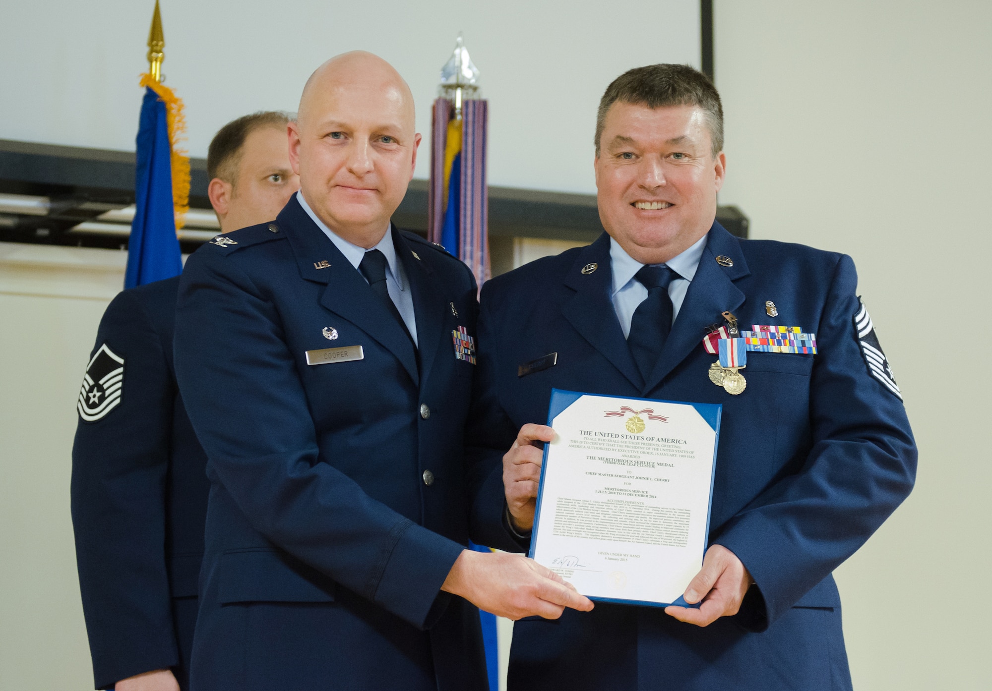 Col. Michael Cooper (left), commander of the 123rd Medical Group, presents Chief Master Sgt. Johnie Cherry with a Meritorious Service Medal during Cherry's retirement ceremony at the Kentucky Air National Guard Base in Louisville, Ky., Feb. 7, 2015. Cherry retired after more than 34 years of service to the active-duty Air Force and Air National Guard. (U.S. Air National Guard photo by 2nd. Lt. James Killen)
