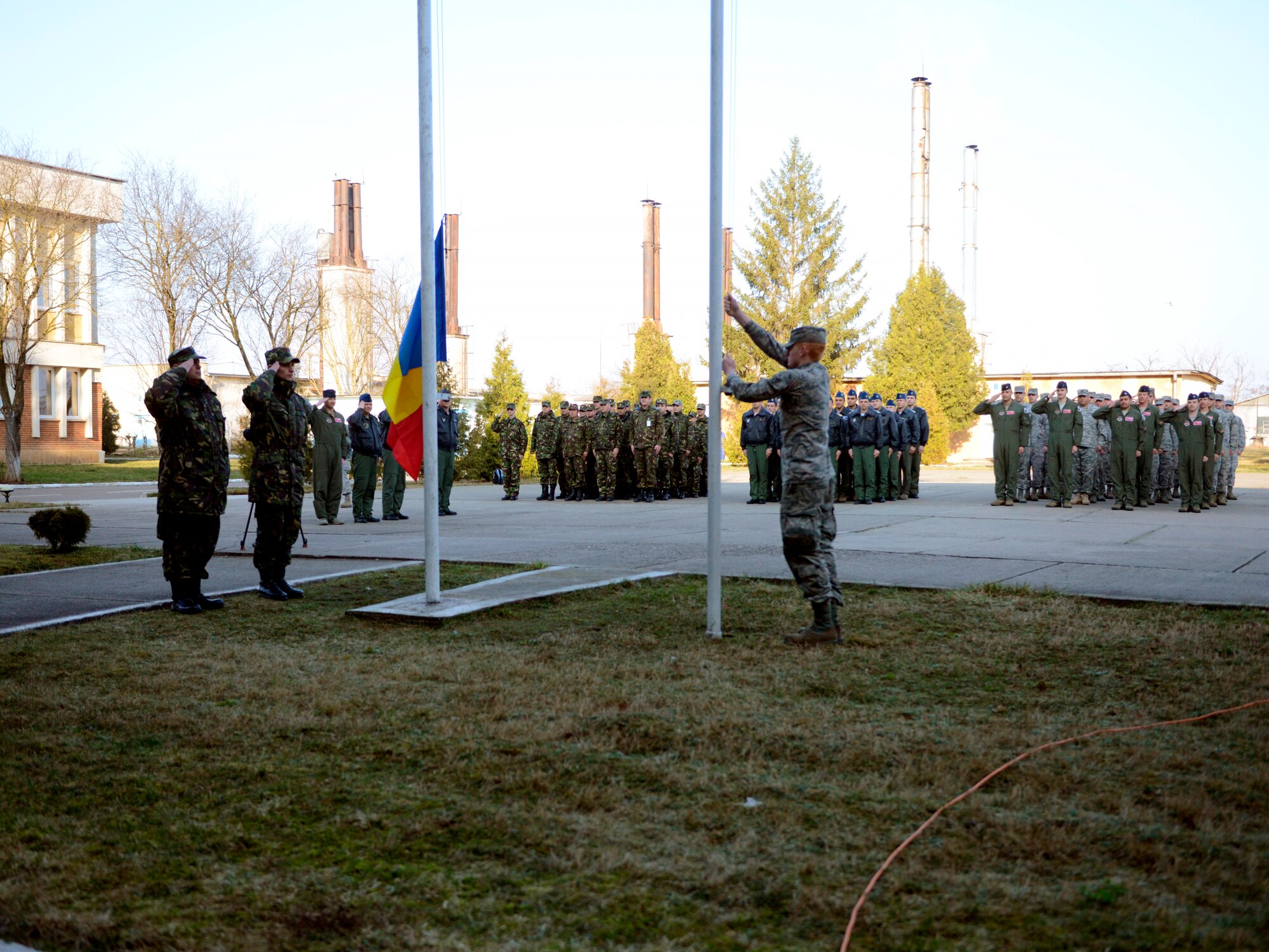 U.S. and Romanian Airmen salute as the American flag is raised during a formal ceremony signifying the start of Dacian Warhawk, A two-week training mission designed to increase the interoperability between the two nations at Campia Turzii, Romania, March 16, 2015. The mission involved Airmen from the 435th Air Ground Operations Wing from Ramstein Air Base, Germany, 52nd Fighter Wing from Spangdahlem Air Base, Germany, and the Romanian Airmen from Campia Turzii, Romania. (U.S. Air Force photo/Staff Sgt. Kris Levasseur)