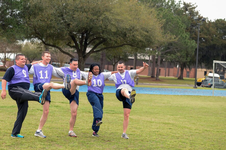 Members of the 93d Air Ground Operations Wing perform a kickline during a game of ultimate Frisbee during their Comprehensive Airman Fitness Day March 13, 2015, at Moody Air Force Base, Ga. During the games, when opposing teams scored, the other team had to perform 10 repetitions of various exercises. (U.S. Air Force photo by Airman Greg Nash/Released)