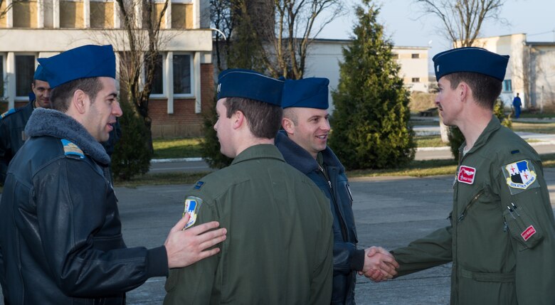U.S. and Romanian pilots greet each other after a ceremony at Campia Turzii, Romania, March 16, 2015. The pilots are participating in Dacian Warhawk, a joint exercise testing and improving the skills of both ground and aircrews. (U.S. Air Force photo/Staff Sgt. Armando A. Schwier-Morales))