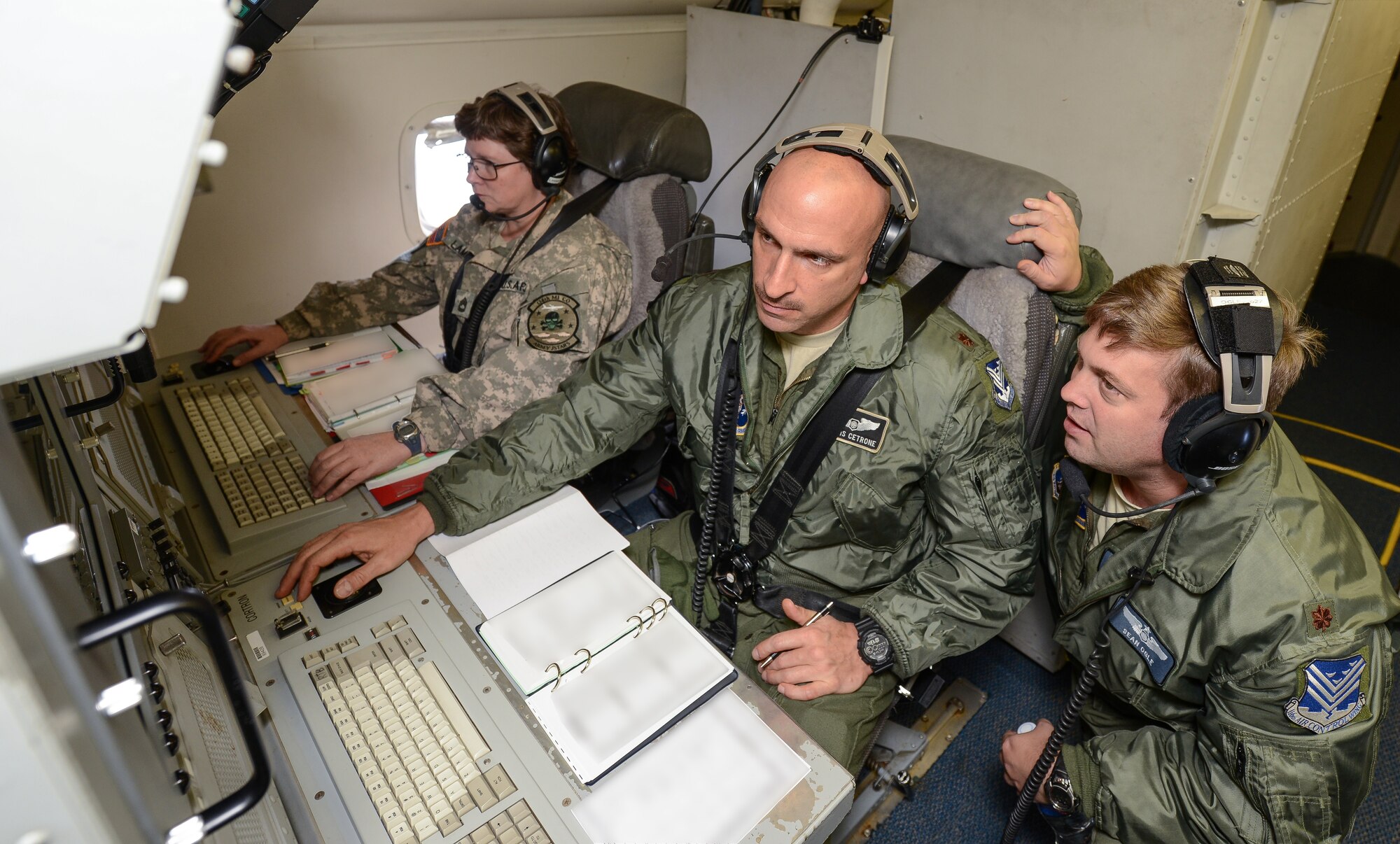 U.S. Air Force aircrew members with the 116th Air Control Wing, Georgia Air National Guard, and a Soldier with the 138th Military Intelligence Company, monitor surveillance information during a mission aboard an E-8C Joint STARS (JSTARS), Robins Air Force Base, Ga., Nov. 15, 2014. The JSTARS platform provides wide-area, all-weather, surface surveillance radar that is used in a combat capacity supporting combatant commanders across the globe. They can also provide valuable data during domestic natural disasters; such as hurricanes and tornadoes, by communicating real-time geographic data to ground personnel to help safely evacuate citizens. (U.S. Air National Guard photo by Tech. Sgt. Regina Young/Released)(Portions of the photo have been blurred and names withheld for security purposes)