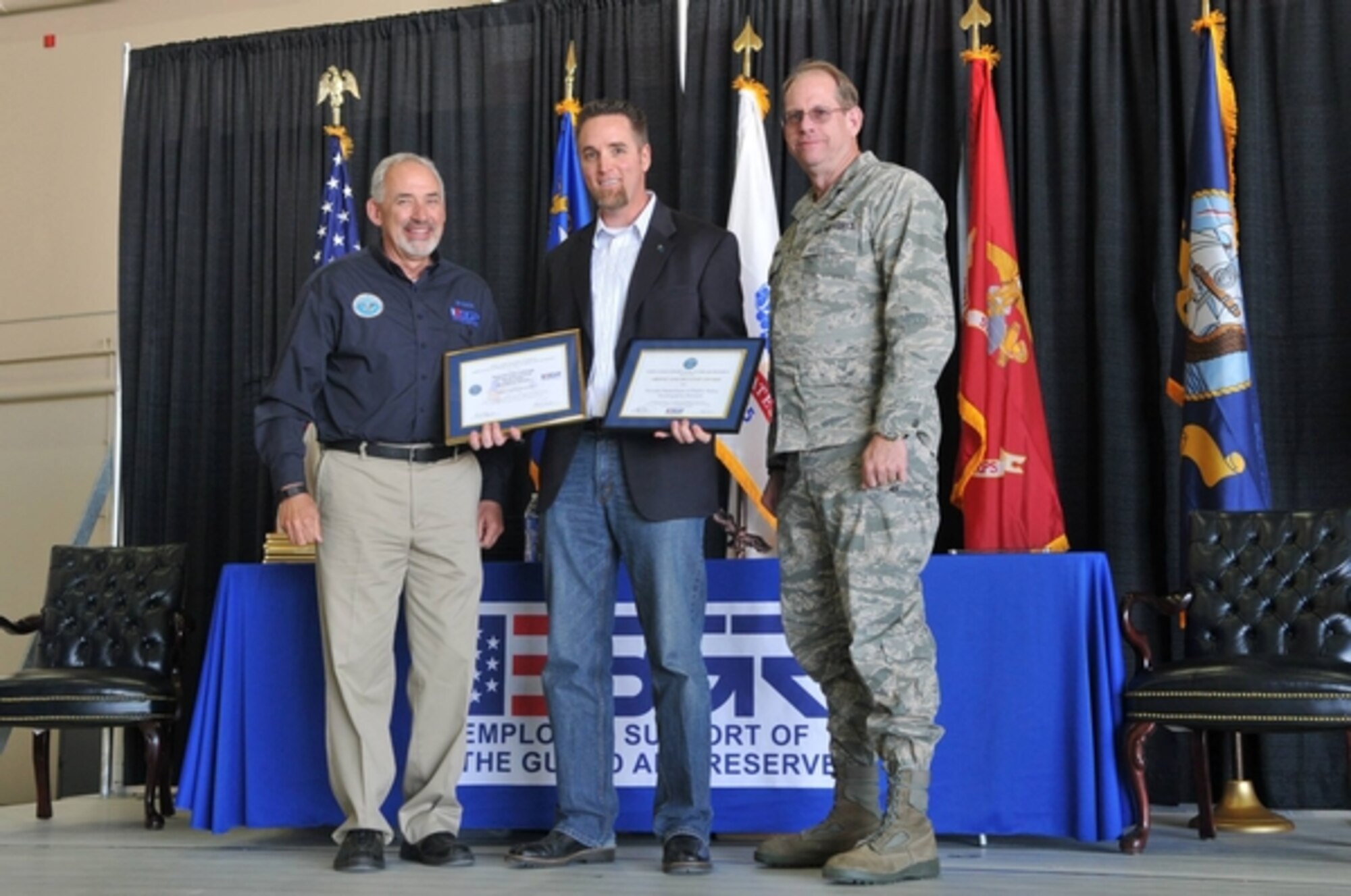 Sgt. Dan Johnson, Nevada Department of Public Safety (center), accepts the Patriot Award from NV ESGR Chairman David Cantrell (left), as Brig. Gen. Burks (right) looks on.  Johnson, along with others, was recognized during the annual ESGR event at Creech Air Force Base in southern Nevada on March 10.  The event thanks and recognizes employers and the communtiy for their support of guardsmen and reservists.  USAF Photo by Tech. Sgt. Emerson Marcus (released). 
