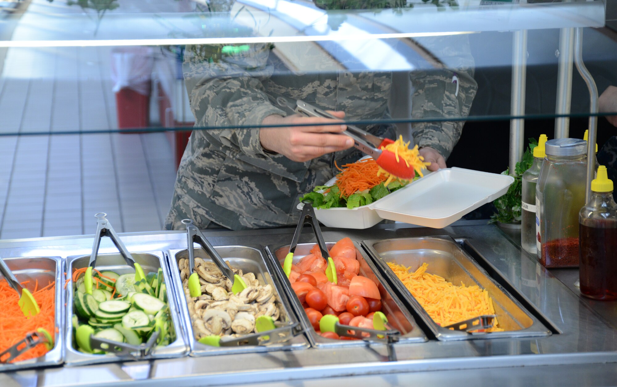 An Airman assembles a salad at Joint Base Andrews, Md., March 16, 2015, with tongs color coded according to the Go For Green program. Go For Green allows Airmen quickly make informed decisions about food choices, with the goal of supporting performance, readiness and resilience. (U.S. Air National Guard photo by Senior Airman John Hillier/Released)