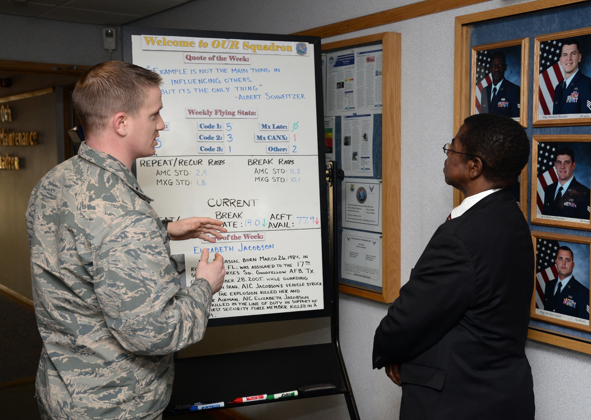 U.S. Air Force 2nd Lt. Jordan Jacobs, left, 100th Aircraft Maintenance Squadron aircraft maintenance unit officer in charge from Timberlake, S.D., explains the unit’s welcome board along with its individual parts and their relation to the mission to Dr. Adedji B. Badiru, Air Force Institute of Technology Dean of the Graduate School of Engineering and Management, March 11, 2015, during his visit to RAF Mildenhall, England. The dean’s visit gave him insight into how the base operates and constantly strives for innovation and mission success. (U.S. Air Force photo by Senior Airman Kate Maurer/Released) 