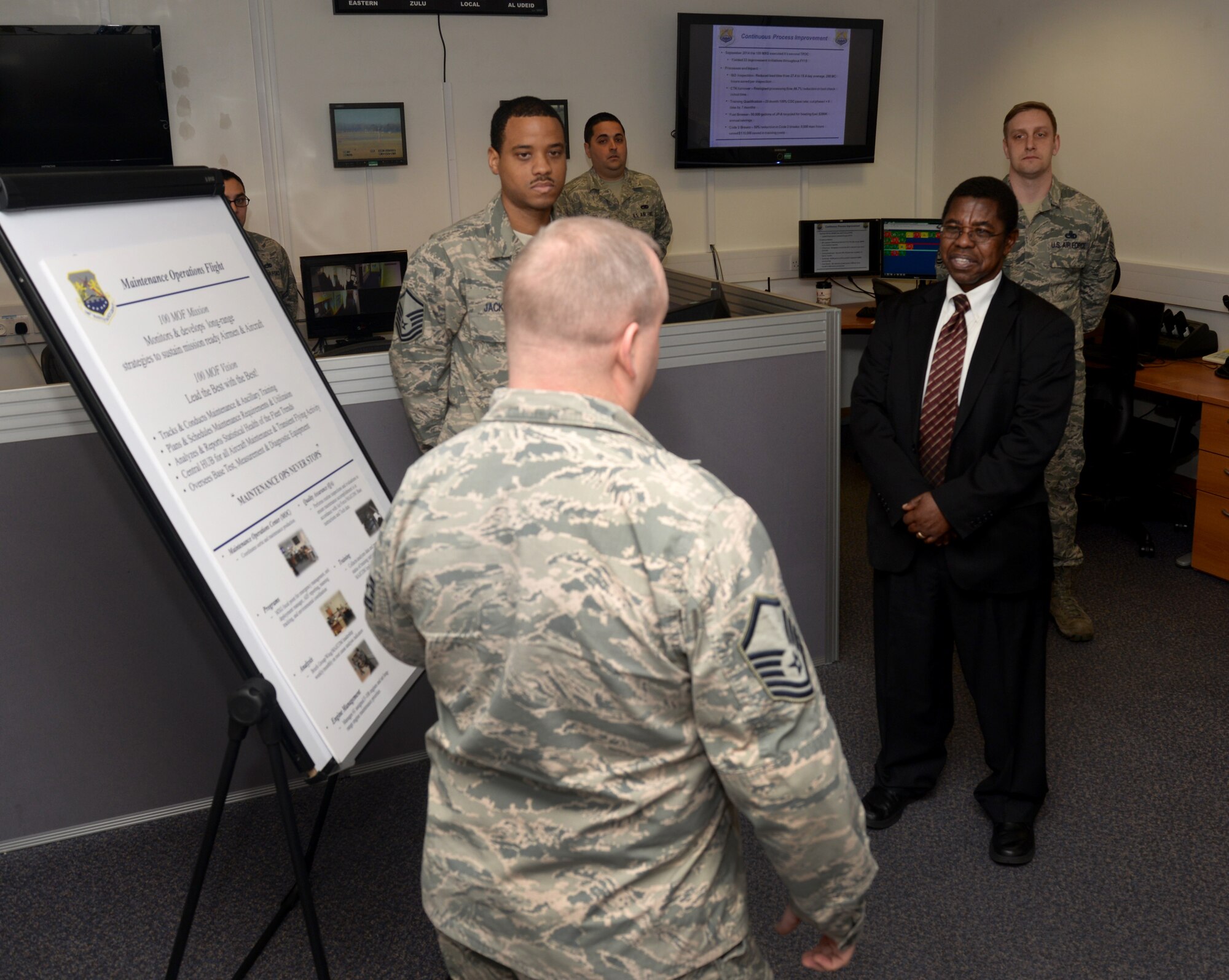 U.S. Air Force Airmen from the 100th Maintenance Group Maintenance Operations Control Center explain their roles in aircraft maintenance and continuous process improvement to Dr. Adedji B. Badiru, second from right, Air Force Institute of Technology Dean of the Graduate School of Engineering and Management, March 11, 2015, during his visit to RAF Mildenhall, England. The dean visited to learn more about the base and what he could bring back to apply to the AFIT curriculum. (U.S. Air Force photo by Senior Airman Kate Maurer/Released) 