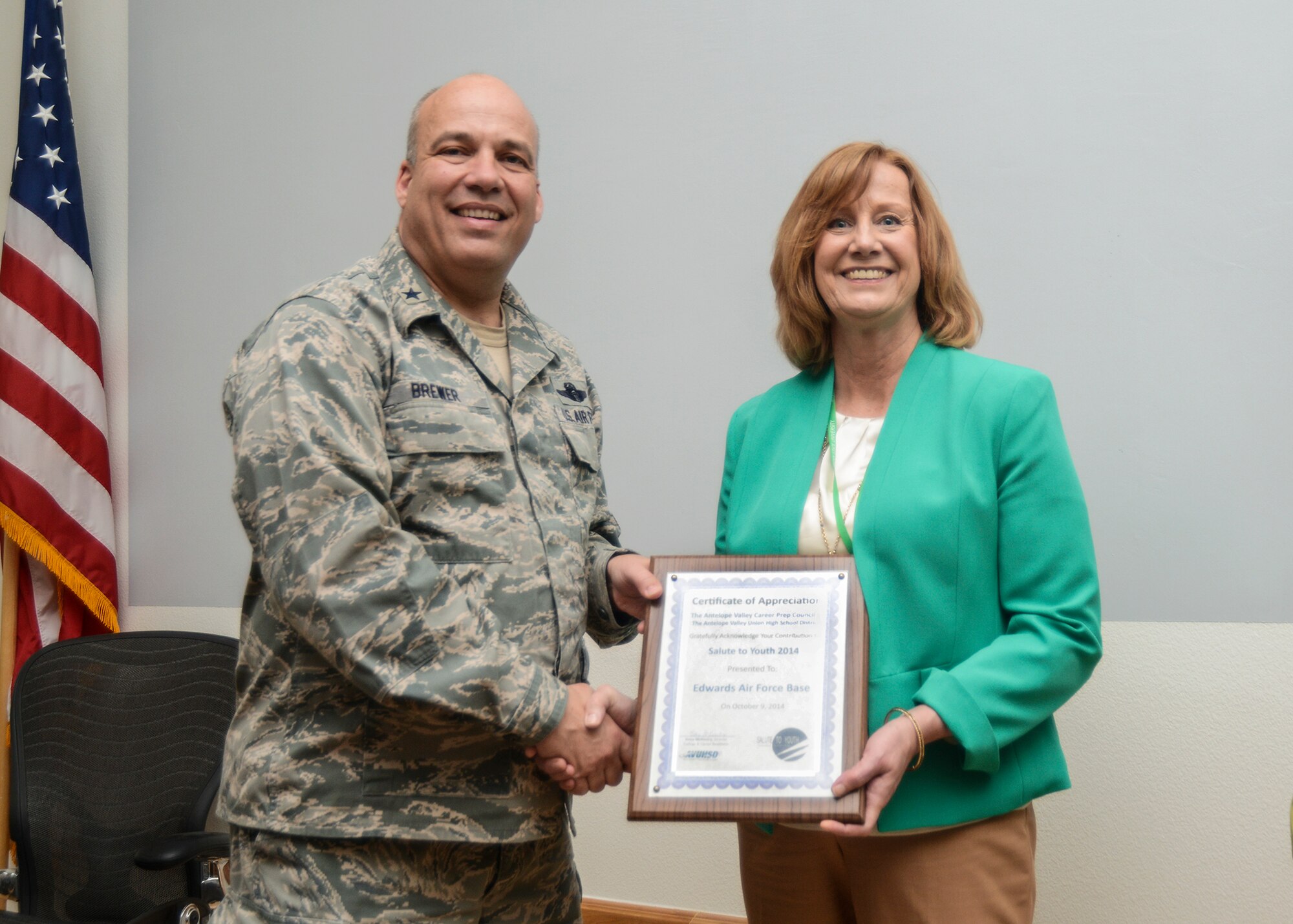 Betsy McKinstry, Antelope Valley Union High School District College and Career director, presented Brig. Gen. Michael Brewer, 412th Test Wing commander, with a certificate of appreciation for Edwards AFB's participation in the district's 2014 Salute to Youth program. The presentation was made during the weekly test wing staff meeting March 17. (U.S. Air Force photo by Rebecca Amber)
