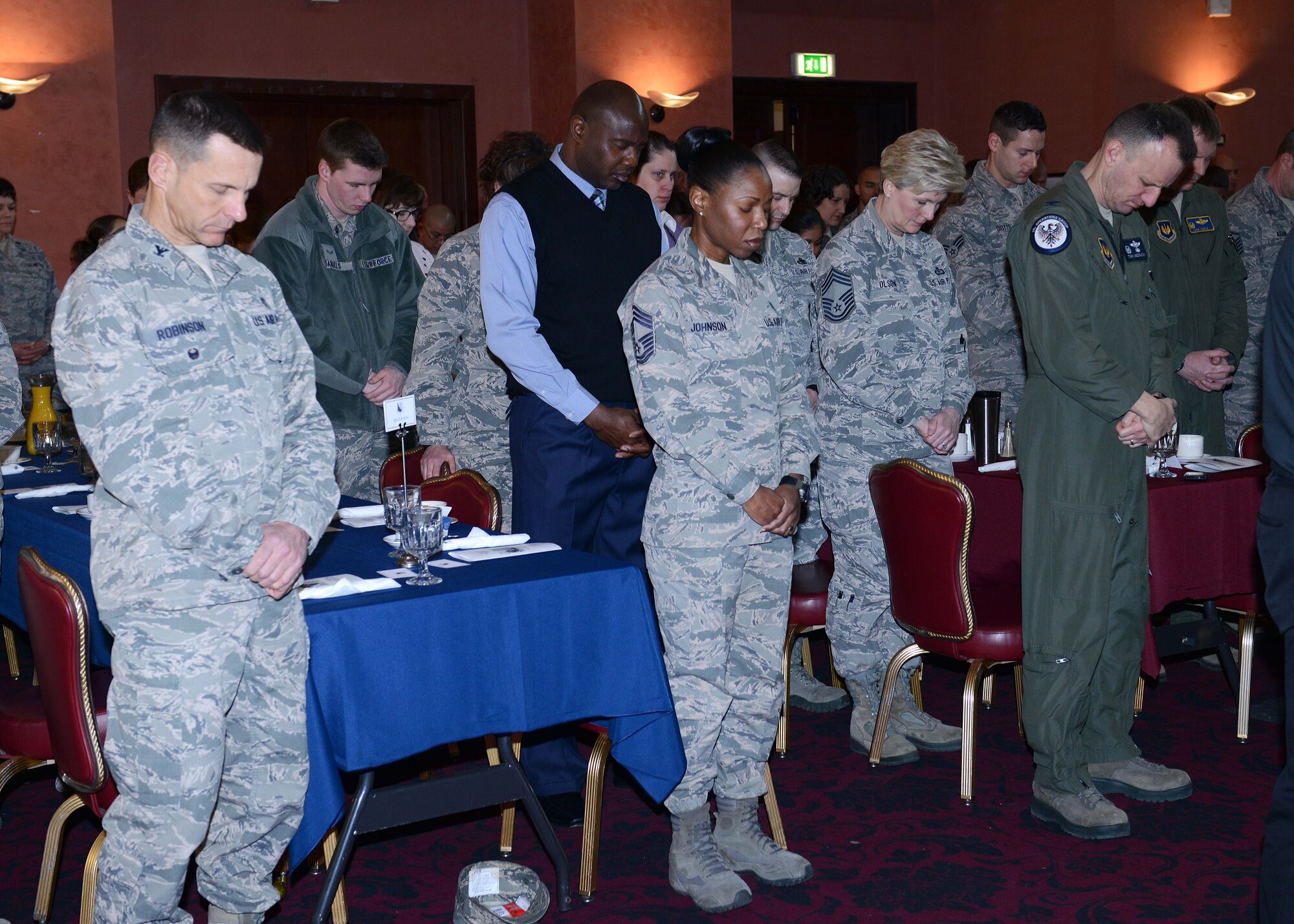 Team Aviano members participate in prayer during the 63rd Annual National Prayer Breakfast, March 18, 2015, at Aviano Air Base, Italy. National prayer breakfasts and luncheons are usually held annually at various locations, including overseas military installations. (U.S. Air Force photo by Airman 1st Class Deana Heitzman/Released)