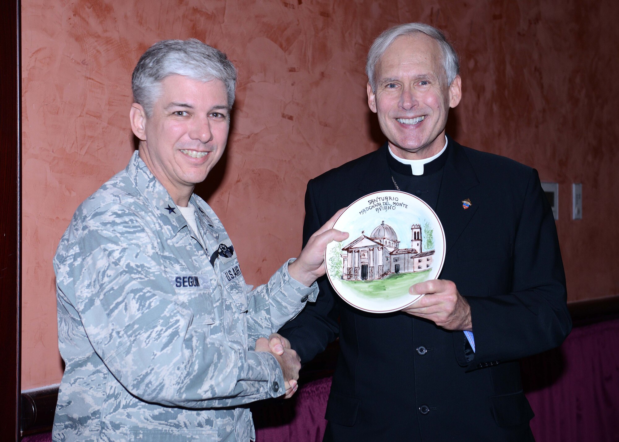 U.S. Air Force Brig. Gen. Barre Seguin, 31st Fighter Wing commander, presents a gift of appreciation to Bishop F. Richard Spencer, Auxiliary Bishop Archdiocese for the Military Services, USA, at the 63rd Annual National Prayer Breakfast, March 18, 2015, at Aviano Air Base, Italy. Bishop Spencer was ordained to Priesthood in 1988 and served with the U.S. Army and Army National Guard.  (U.S. Air Force photo by Airman 1st Class Deana Heitzman/Released)