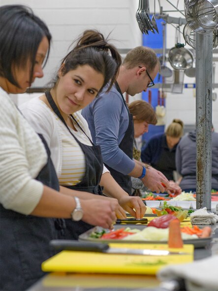 VANCE AIR FORCE BASE, Okla. -- Stacy Ann Smith, a 25th Flying Training Squadron spouse, chops vegetables with classmates at Autry Technology Center in Enid, March 2. Team Vance enjoyed the first night of a four-part culinary course coordinated by the base's Single Airman Programming Initiative. While SAPI funds are initially allotted for single Airmen, opportunities can be extended to the greater military community. (U.S. Air Force photo / David Poe)