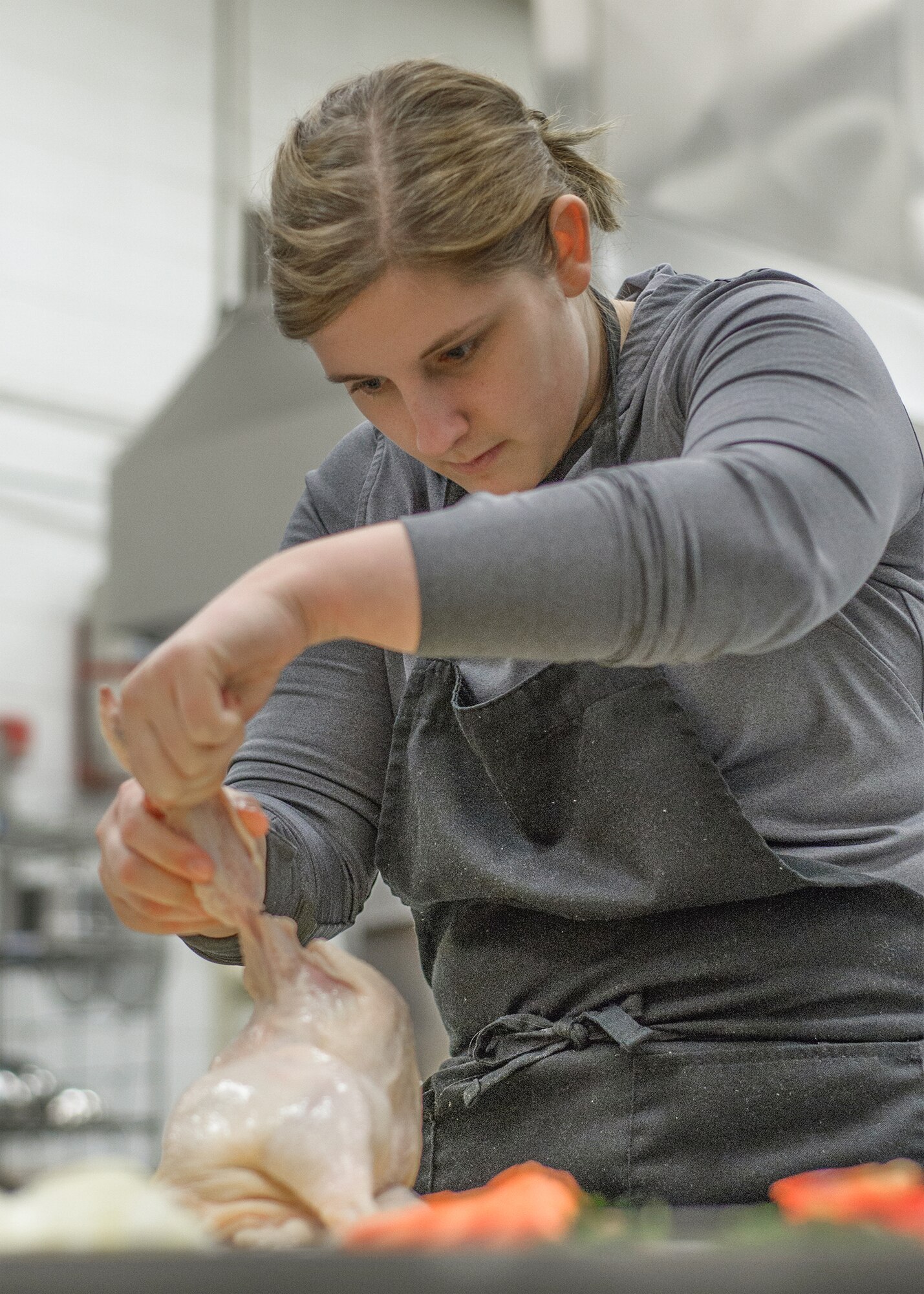 VANCE AIR FORCE BASE, Okla. -- Airman 1st Class Ariel Schlenther, a 71st Medical Operations Squadron Airman, separates a chicken at Autry Technology Center in Enid, Oklahoma, March 2. “I learned a lot on Monday, and I actually applied it to my dinner recipes this past week,” Schlenther said of the Single Airman program-organized class. “I love to cook and thought this would be a great opportunity.” (U.S. Air Force photo / David Poe)