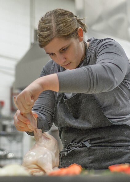 VANCE AIR FORCE BASE, Okla. -- Airman 1st Class Ariel Schlenther, a 71st Medical Operations Squadron Airman, separates a chicken at Autry Technology Center in Enid, Oklahoma, March 2. “I learned a lot on Monday, and I actually applied it to my dinner recipes this past week,” Schlenther said of the Single Airman program-organized class. “I love to cook and thought this would be a great opportunity.” (U.S. Air Force photo / David Poe)