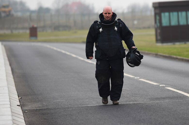 Royal Air Force Sergeant Mac McLachlan, with the 5131 Bomb Disposal Squadron, walks back from the RAF Alconbury, England, large vehicle inspection gate following a training exercise, March 17, 2015. McLachlan, who is based at RAF Wittering, responded to the simulated incident and assisted Airmen from the 423rd Security Force Squadron in their response. (U.S. Air Force photo by Staff Sgt. Jarad A. Denton/Released) 
