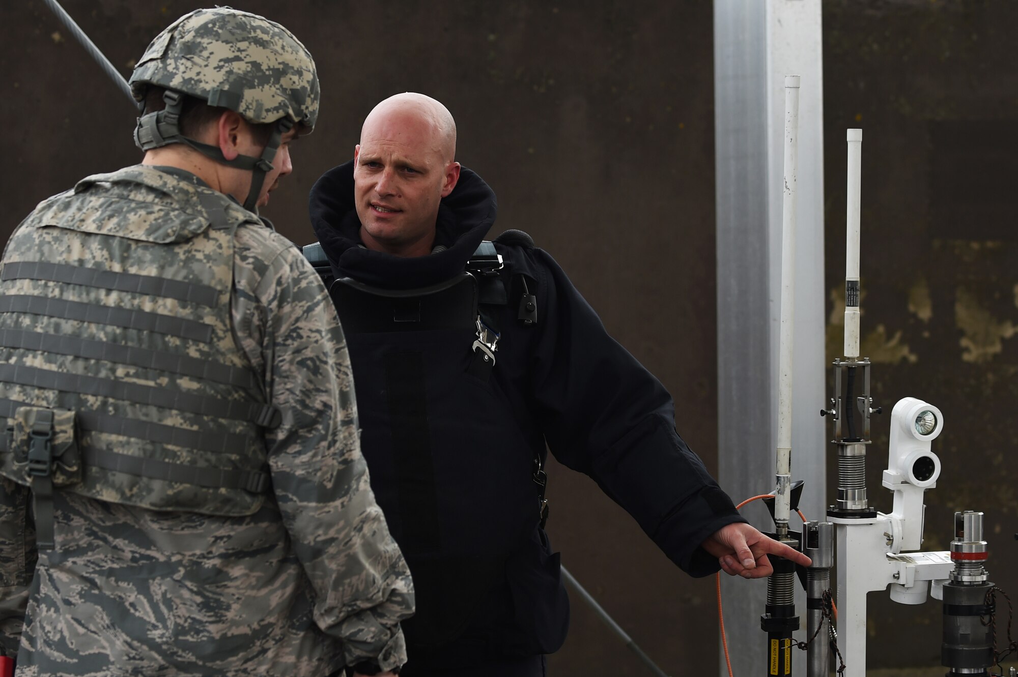 Royal Air Force Sergeant Mac McLachlan, with the 5131 Bomb Disposal Squadron at RAF Wittering, right, explains the functions and capabilities of a bomb disposal robot to U.S. Air Force Capt. Jesse Sandstrom, 423rd Security Forces Squadron operations officer, during a training exercise at RAF Alconbury, England, March 17, 2015. The exercise allowed U.S. and UK Service members to work together and properly manage and eliminate a threat to the installation. (U.S. Air Force photo by Staff Sgt. Jarad A. Denton/Released)